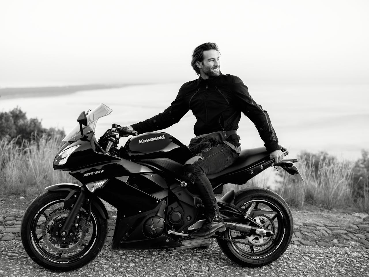 Man on a black Kawasaki motorcycle enjoying a scenic view in Lisbon.